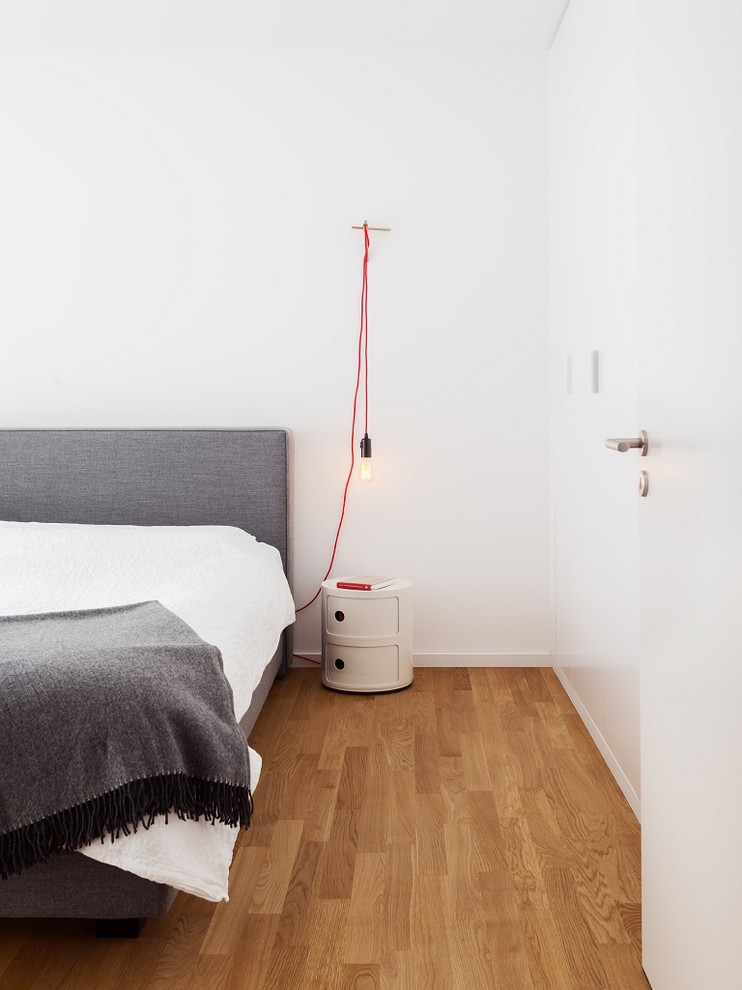 Idee per una camera matrimoniale scandinava di medie dimensioni con pavimento in legno massello medio e pareti bianche