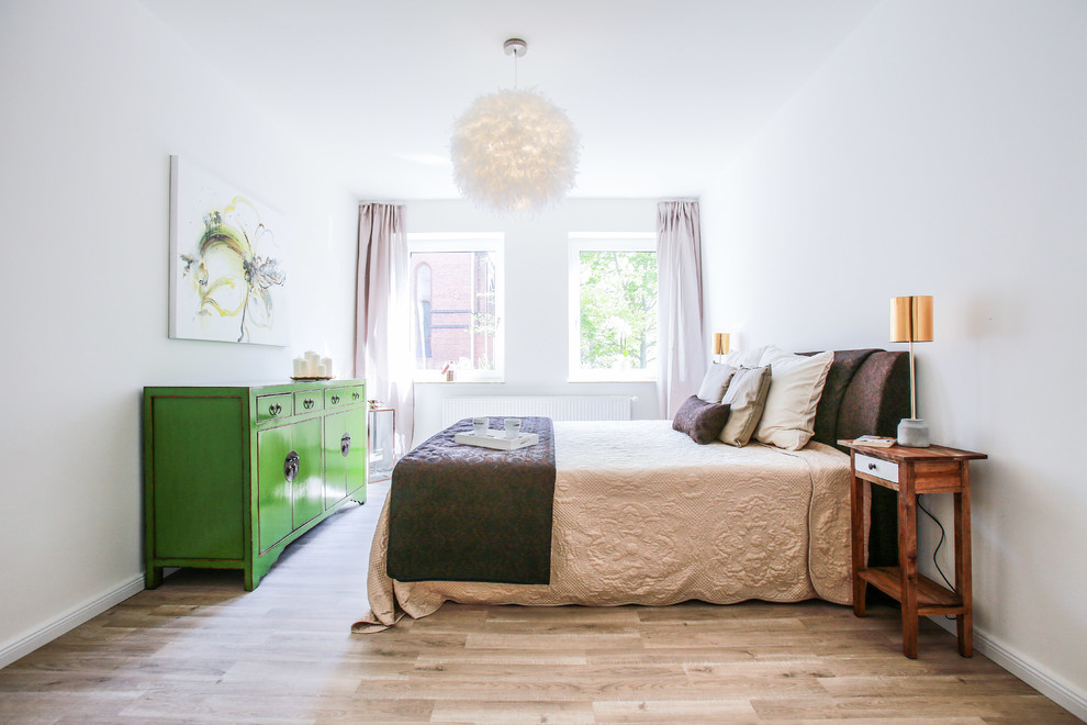 Foto de habitación de invitados de estilo de casa de campo sin chimenea con paredes blancas y suelo de madera clara
