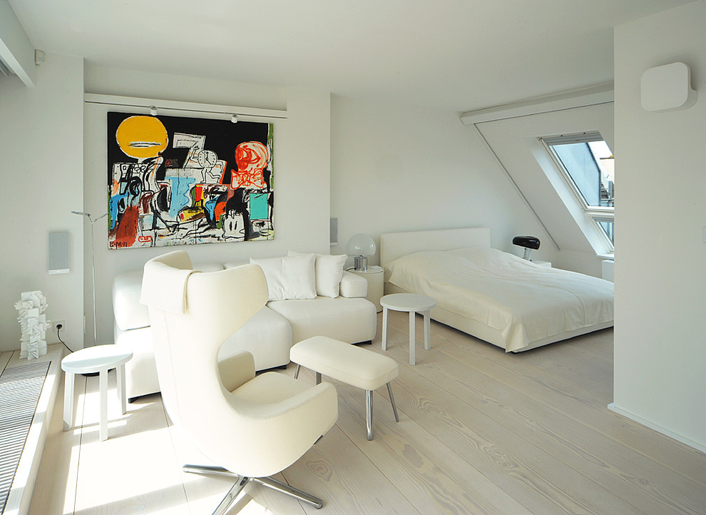 Großes Modernes Schlafzimmer ohne Kamin mit weißer Wandfarbe und gebeiztem Holzboden in Berlin