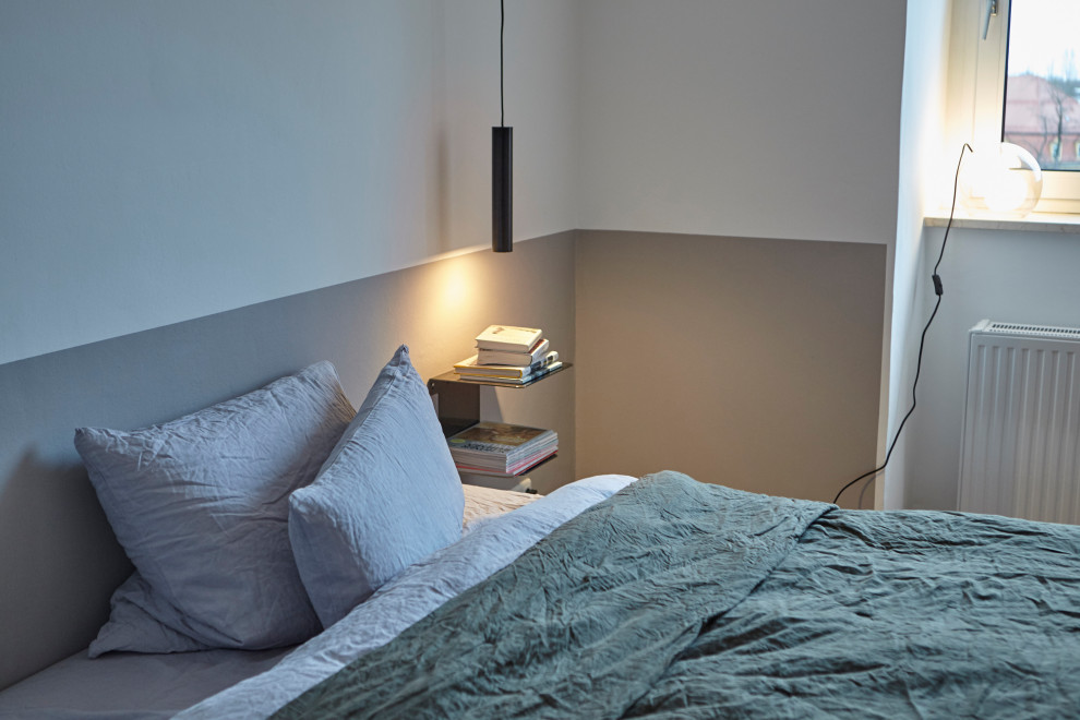 Example of a mid-sized danish master medium tone wood floor bedroom design in Munich with gray walls
