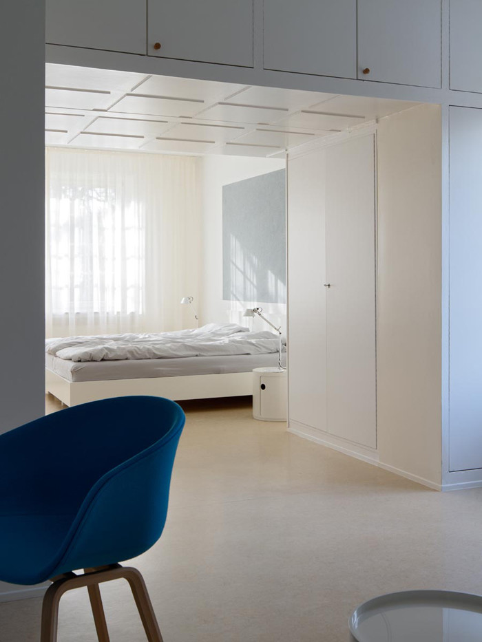Aménagement d'une chambre avec moquette contemporaine de taille moyenne avec un mur blanc.