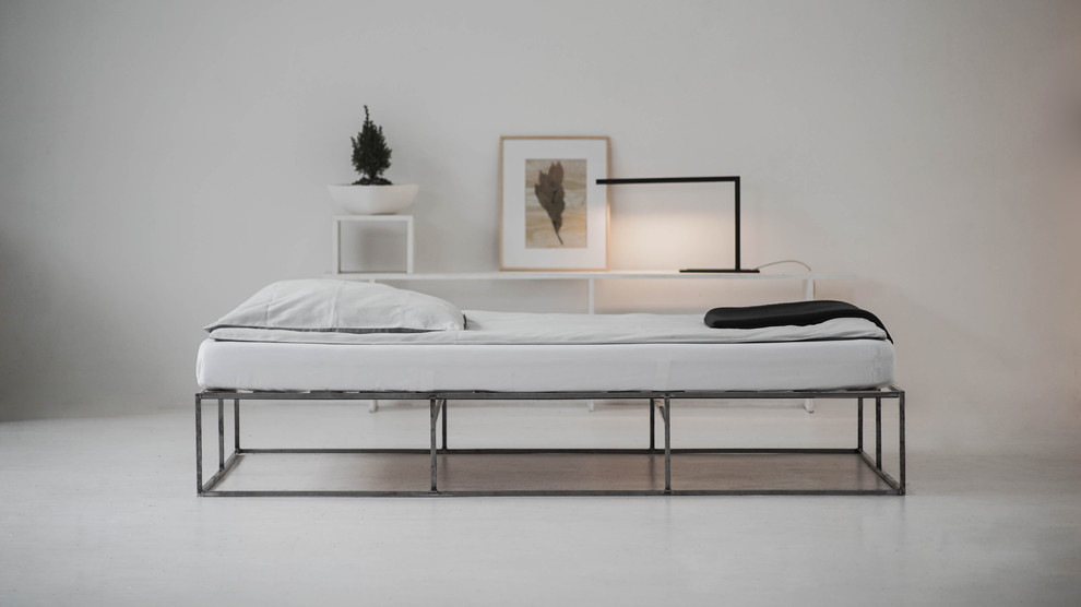 Foto di una camera da letto minimalista con pareti bianche e pavimento bianco