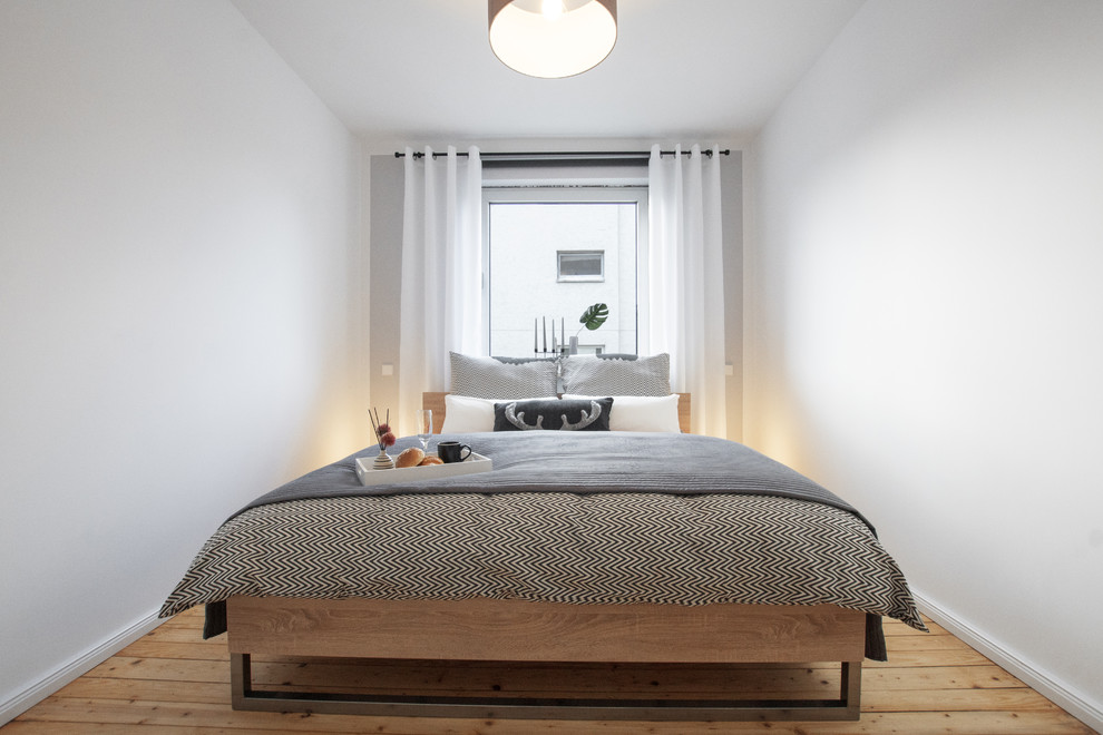 Kleines Nordisches Hauptschlafzimmer mit grauer Wandfarbe und hellem Holzboden in Köln