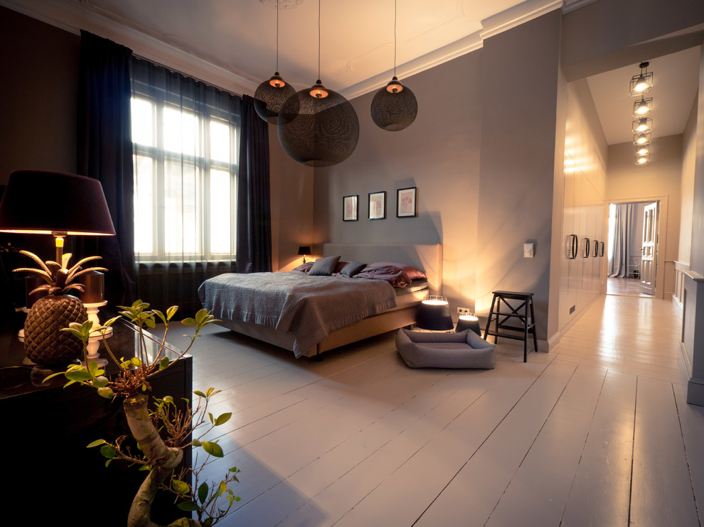 Großes Schlafzimmer ohne Kamin mit lila Wandfarbe und hellem Holzboden in Berlin