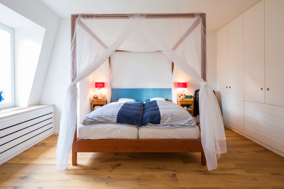 Immagine di una camera da letto scandinava con pareti bianche, parquet scuro e nessun camino