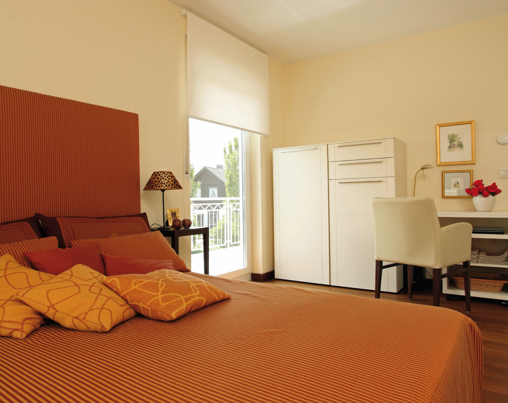 他の地域にあるコンテンポラリースタイルのおしゃれな客用寝室 (黄色い壁、無垢フローリング、暖炉なし、茶色い床) のインテリア
