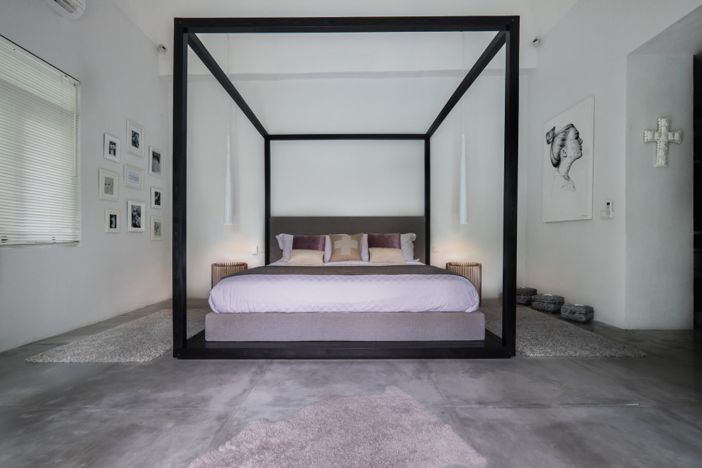 Inspiration for a large contemporary master bedroom with white walls, concrete flooring and grey floors.