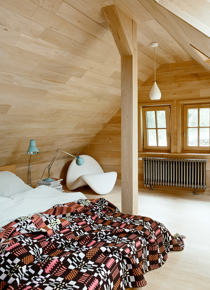 Ejemplo de dormitorio principal actual de tamaño medio sin chimenea con suelo de madera clara y paredes marrones