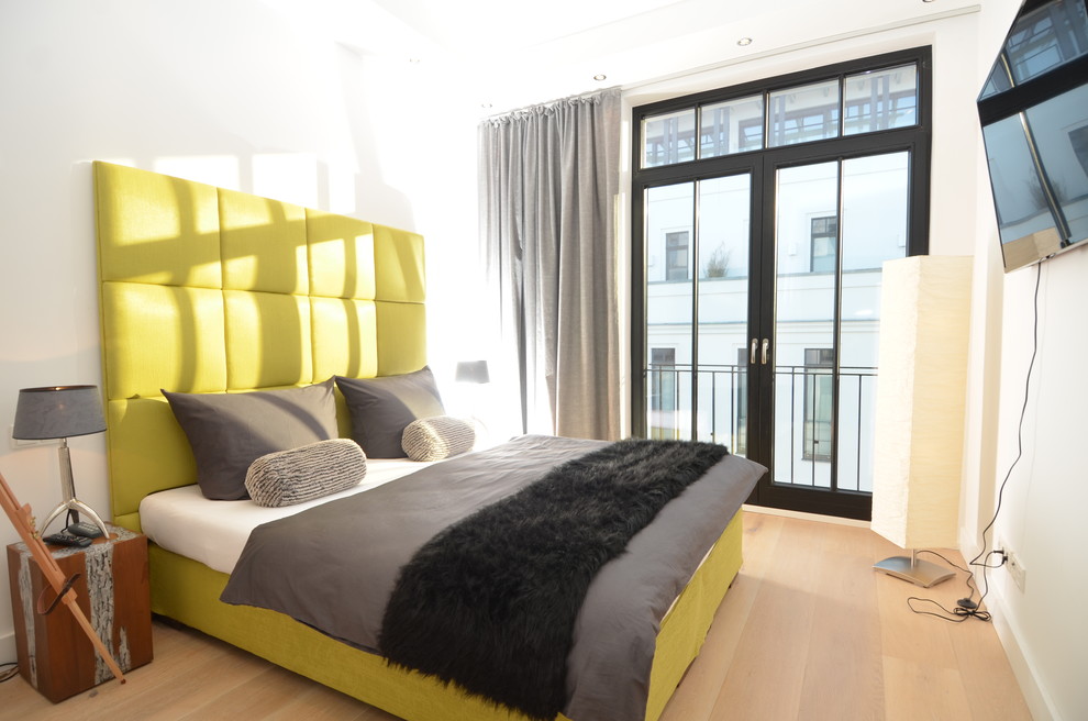 Mittelgroßes Modernes Schlafzimmer ohne Kamin mit weißer Wandfarbe und hellem Holzboden in Sonstige