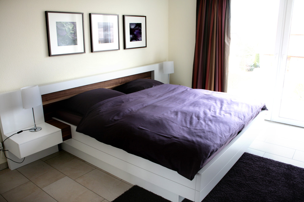 Immagine di una camera da letto minimal di medie dimensioni con pareti gialle, pavimento in pietra calcarea e nessun camino