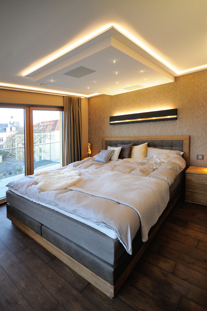 Modernes Hauptschlafzimmer mit bunten Wänden, braunem Holzboden und braunem Boden in Dresden
