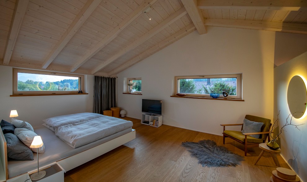 Cette image montre une chambre parentale design avec un sol en bois brun.
