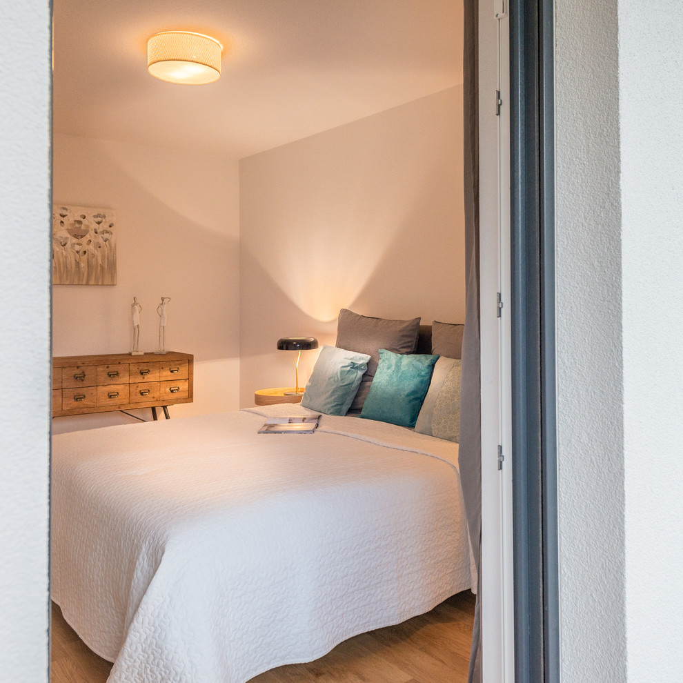 Esempio di una piccola camera da letto scandinava con pareti bianche, pavimento in legno massello medio, nessun camino e pavimento marrone