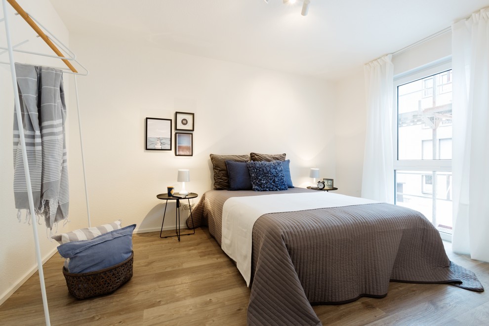 Aménagement d'une petite chambre parentale scandinave avec un mur blanc, un sol en bois brun et un sol marron.