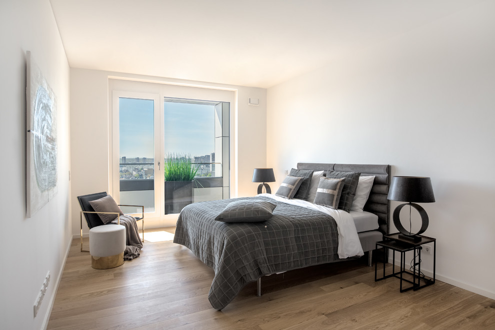 Modernes Hauptschlafzimmer ohne Kamin mit weißer Wandfarbe, braunem Holzboden und braunem Boden in Frankfurt am Main
