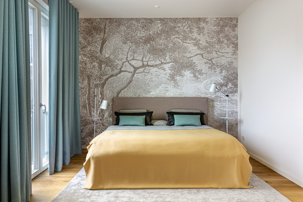 Modelo de dormitorio principal ecléctico con paredes beige, suelo de madera clara y papel pintado