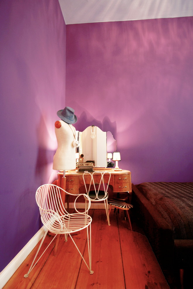Diseño de dormitorio principal ecléctico de tamaño medio sin chimenea con paredes púrpuras y suelo de madera en tonos medios