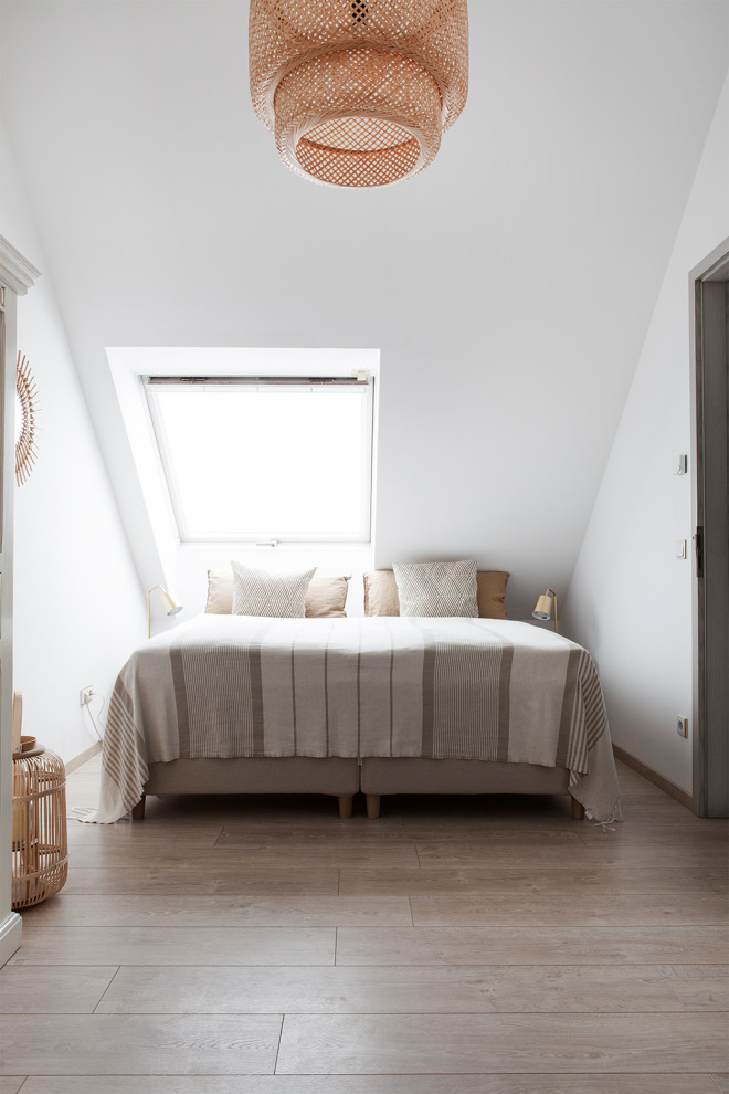 Mittelgroßes Skandinavisches Hauptschlafzimmer mit weißer Wandfarbe und Laminat in Berlin