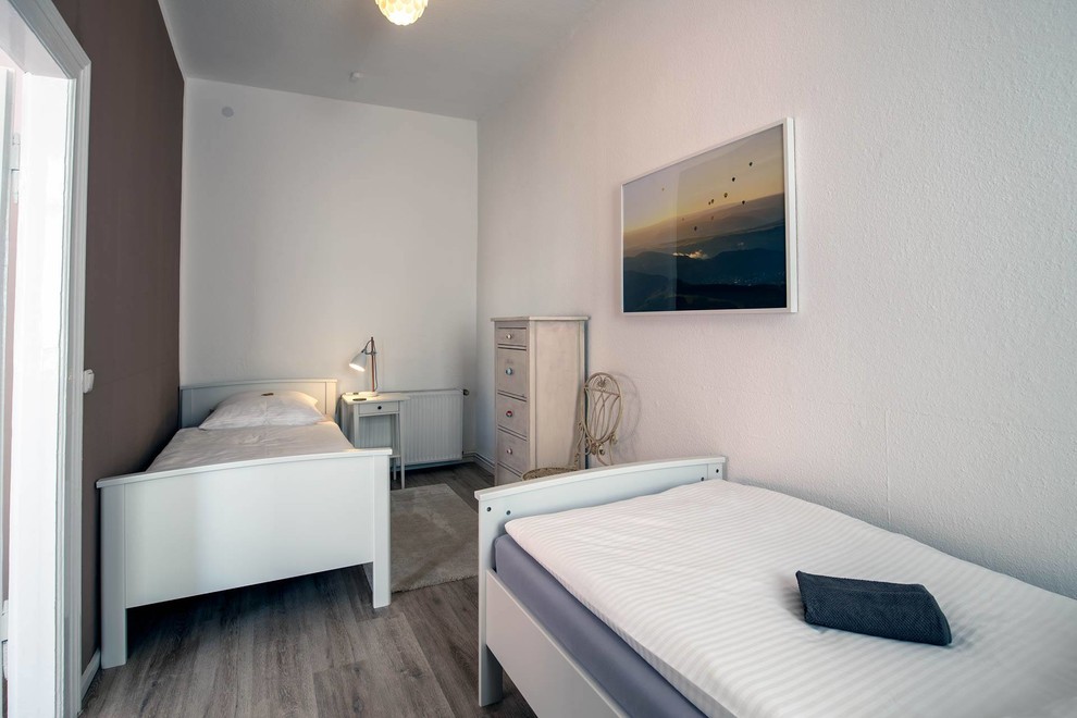 Kleines Landhausstil Gästezimmer mit brauner Wandfarbe, Vinylboden, braunem Boden, Tapetendecke und Tapetenwänden in Hannover