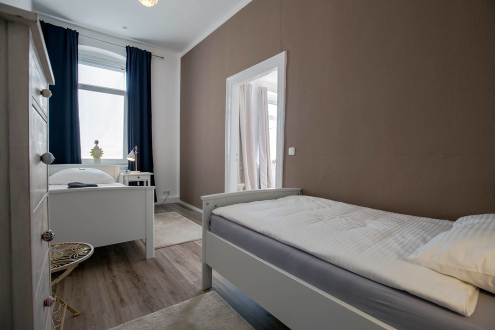 Kleines Country Gästezimmer mit brauner Wandfarbe, beigem Boden, Vinylboden, Tapetendecke und Tapetenwänden in Hannover
