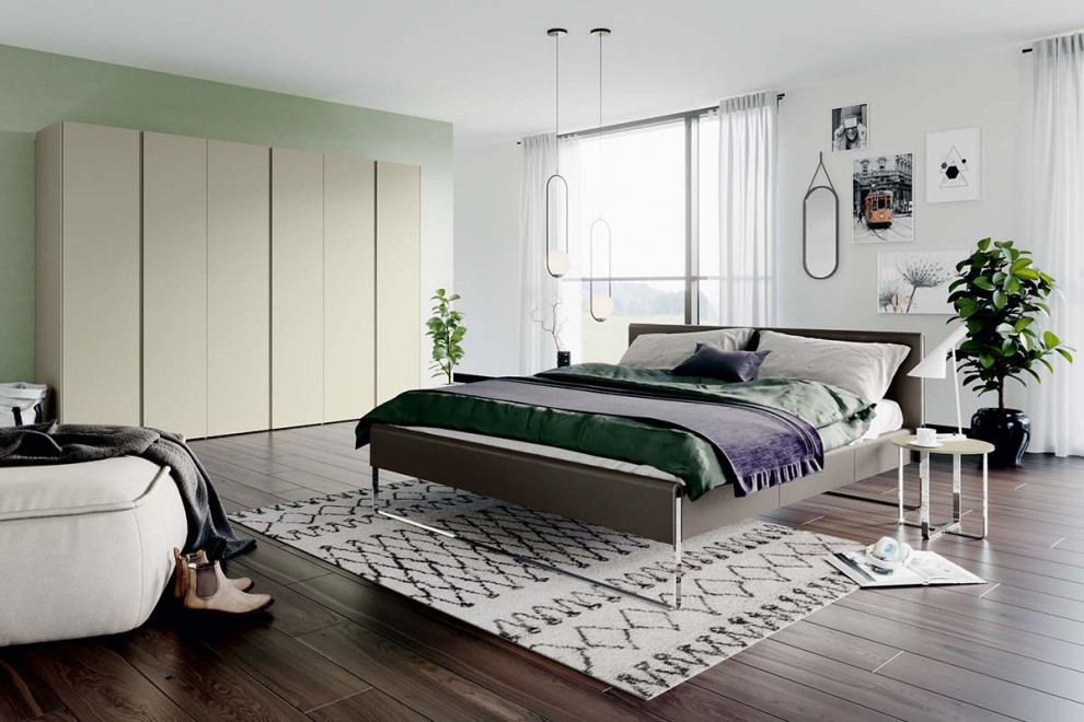 Modern inredning av ett sovrum, med gröna väggar och brunt golv