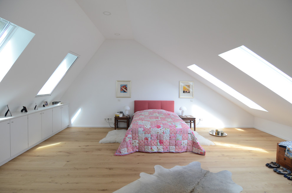 Photo of an expansive contemporary master loft bedroom in Bremen with white walls, light hardwood flooring and no fireplace.