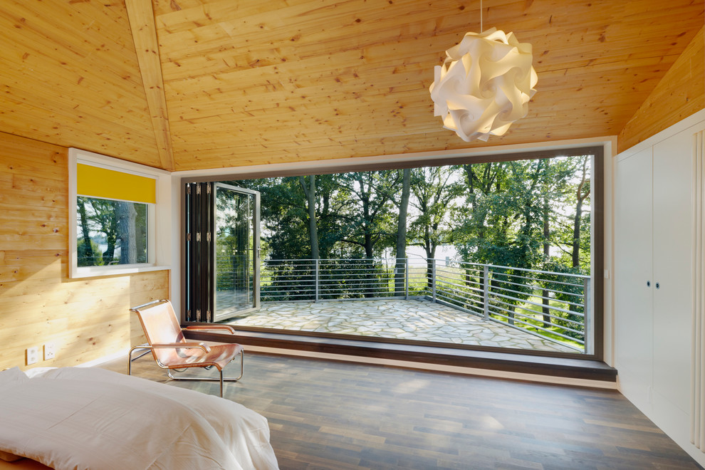 Großes Modernes Hauptschlafzimmer ohne Kamin mit brauner Wandfarbe und dunklem Holzboden in Berlin