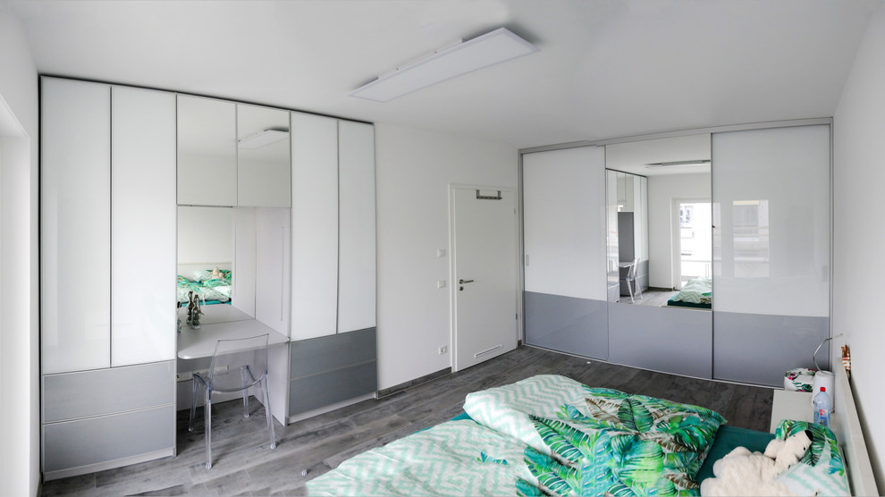 Foto de dormitorio principal moderno de tamaño medio sin chimenea con paredes blancas, suelo de pizarra y suelo gris