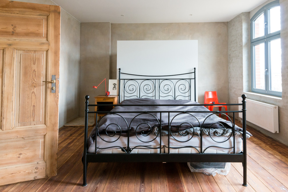 Foto di una camera degli ospiti design di medie dimensioni con pavimento in legno massello medio, nessun camino e pareti grigie