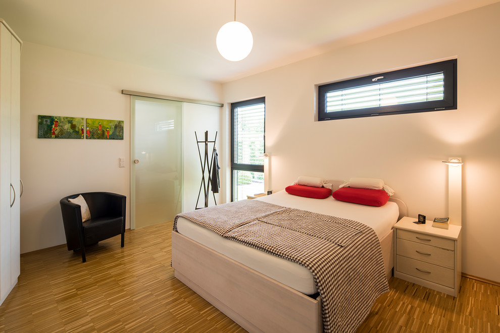 Modernes Schlafzimmer ohne Kamin, im Loft-Style mit weißer Wandfarbe, hellem Holzboden und braunem Boden in Sonstige