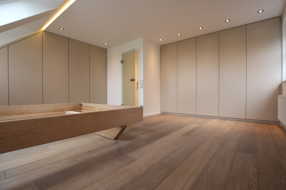 Idee per una camera matrimoniale design di medie dimensioni con pareti bianche e pavimento in legno massello medio