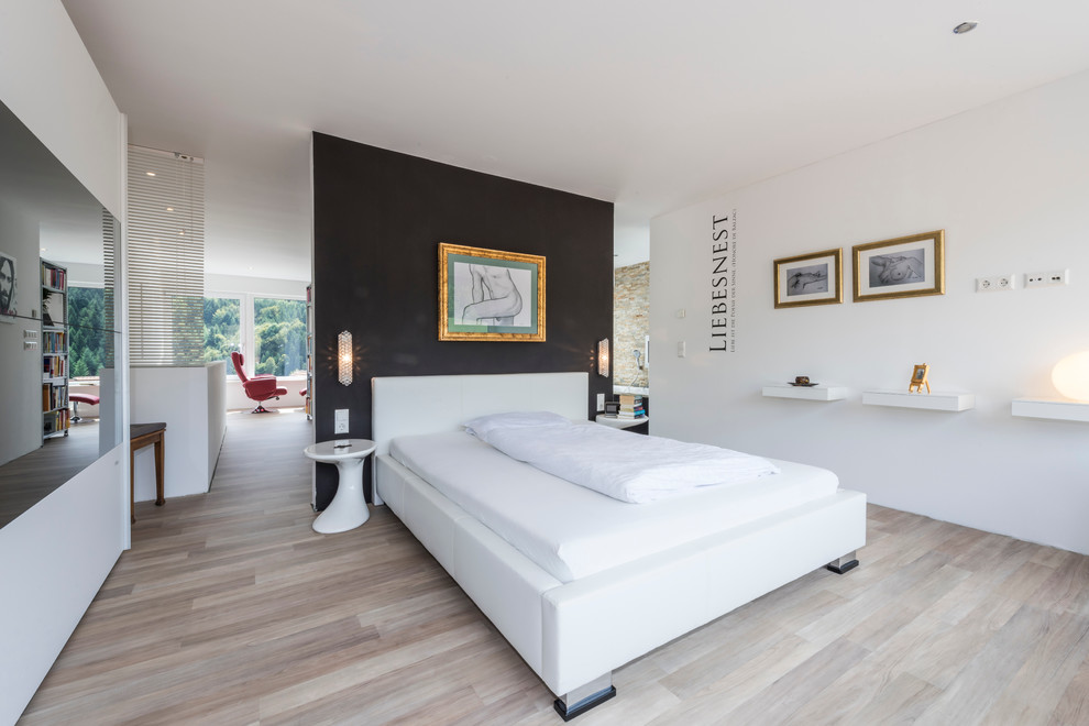 Großes Modernes Hauptschlafzimmer ohne Kamin mit schwarzer Wandfarbe und hellem Holzboden in Frankfurt am Main
