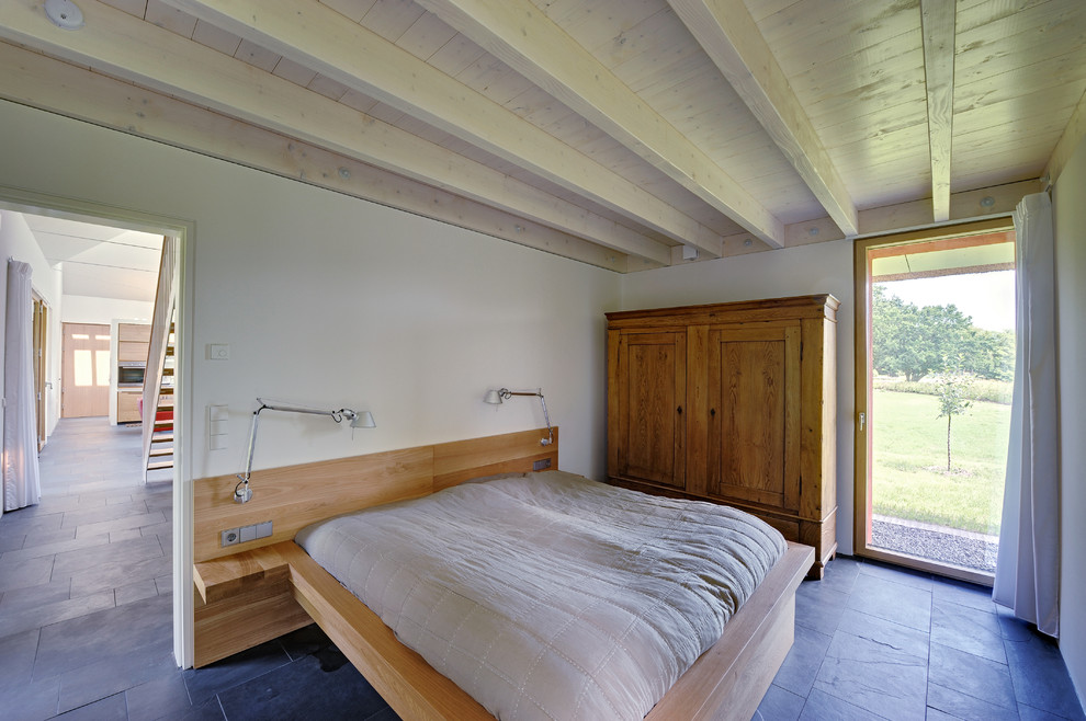 Landhaus Hauptschlafzimmer ohne Kamin mit weißer Wandfarbe und Schieferboden in Berlin
