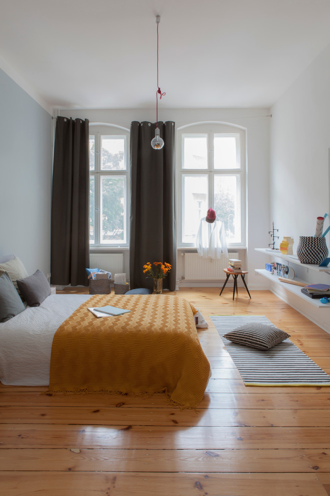 Großes Skandinavisches Hauptschlafzimmer ohne Kamin mit weißer Wandfarbe, braunem Holzboden und braunem Boden in Berlin