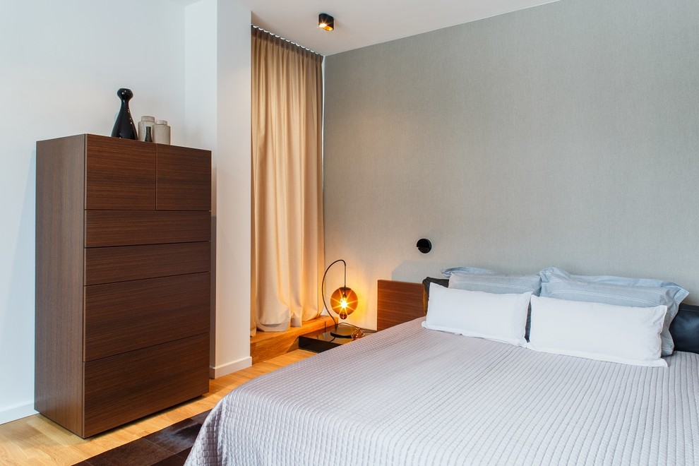 Mittelgroßes Modernes Hauptschlafzimmer ohne Kamin mit gebeiztem Holzboden, grauer Wandfarbe und beigem Boden in Berlin