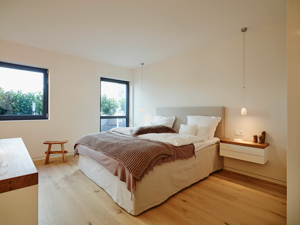 Mittelgroßes Modernes Schlafzimmer mit weißer Wandfarbe und hellem Holzboden in Frankfurt am Main