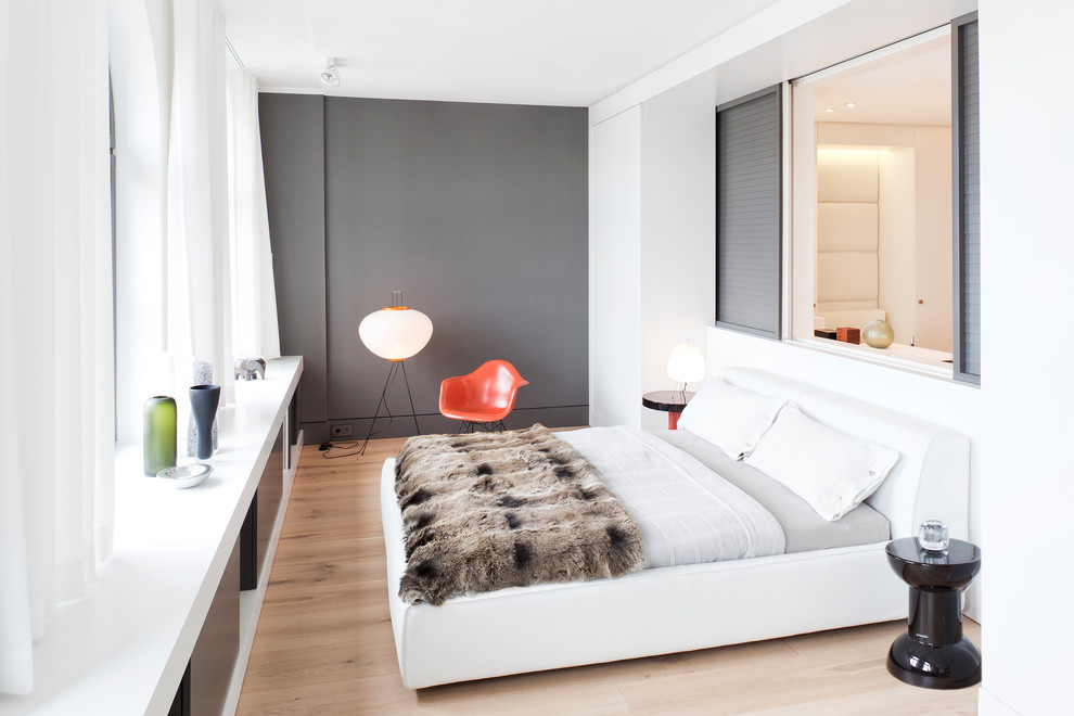 На фото: хозяйская спальня среднего размера в современном стиле с белыми стенами и светлым паркетным полом без камина