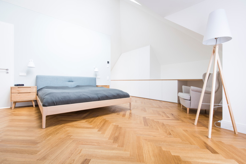 Exemple d'une grande chambre parentale scandinave avec un mur blanc, un sol en bois brun, aucune cheminée et un sol marron.