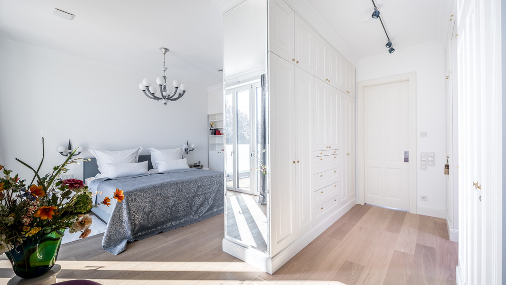 Foto de dormitorio principal tradicional con paredes blancas, suelo de madera clara y suelo beige