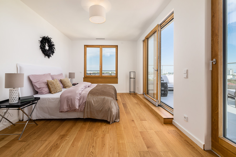 This is an example of a medium sized contemporary master bedroom in Munich with white walls, medium hardwood flooring, beige floors and no fireplace.
