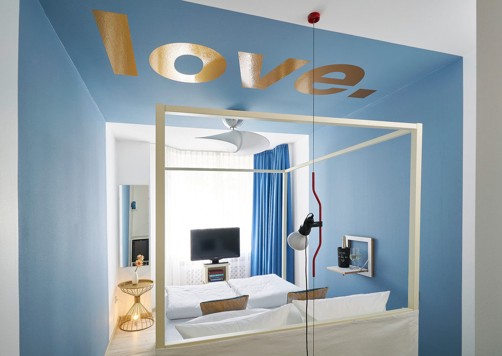 Modelo de habitación de invitados ecléctica pequeña con paredes azules, suelo vinílico y suelo beige