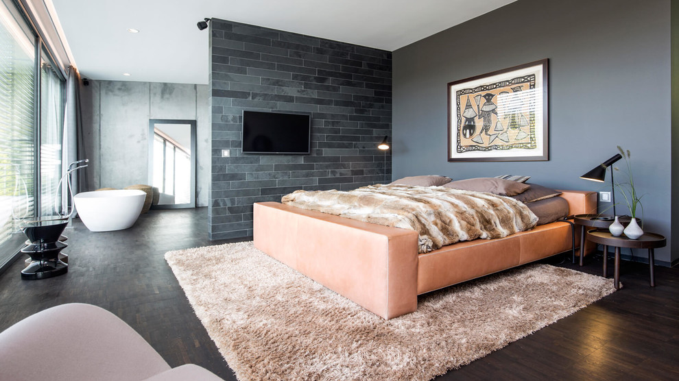 Großes Modernes Hauptschlafzimmer ohne Kamin mit grauer Wandfarbe, dunklem Holzboden und braunem Boden in Dortmund