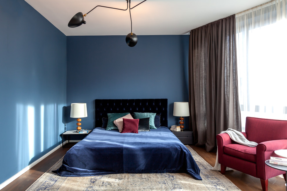 На фото: хозяйская спальня среднего размера в современном стиле с синими стенами и коричневым полом с
