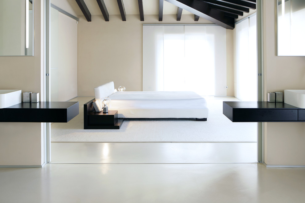 Foto de dormitorio tipo loft moderno grande con paredes beige y suelo de cemento