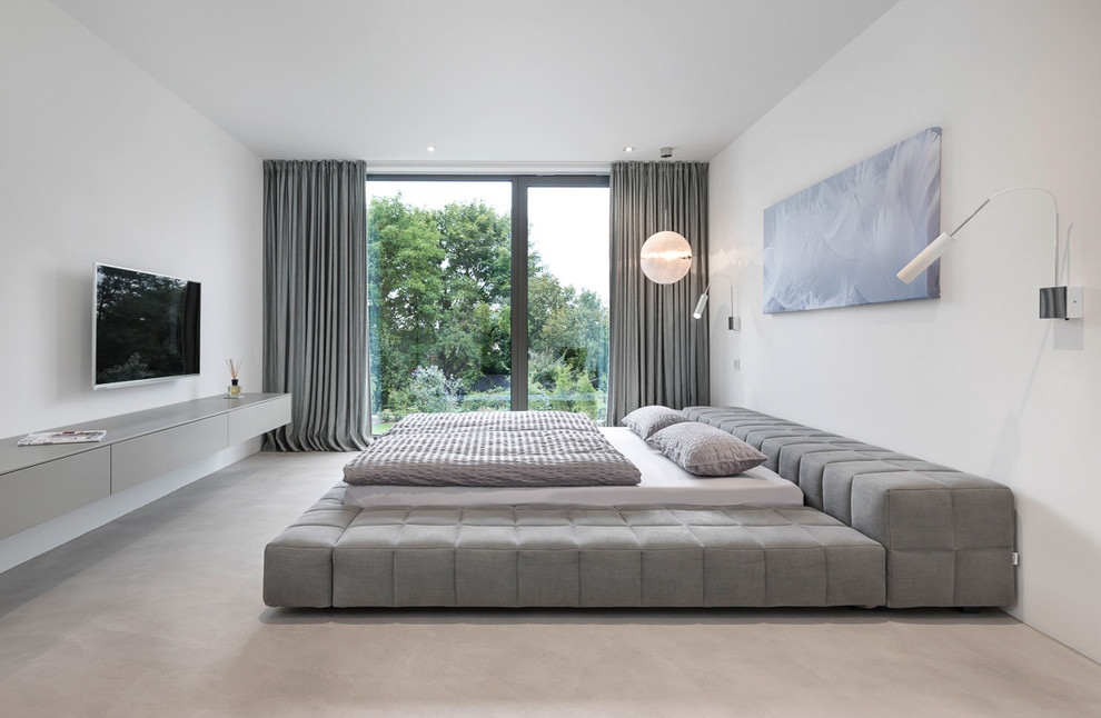 Diseño de dormitorio principal y gris y blanco moderno grande sin chimenea con paredes blancas y moqueta