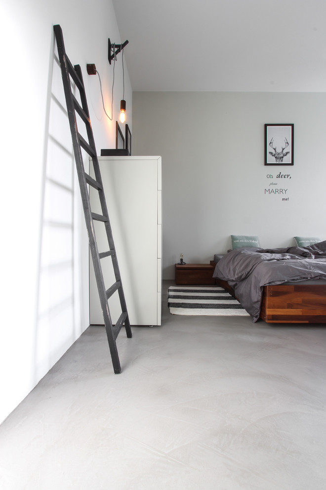 Foto de dormitorio principal escandinavo de tamaño medio con paredes grises y suelo de cemento