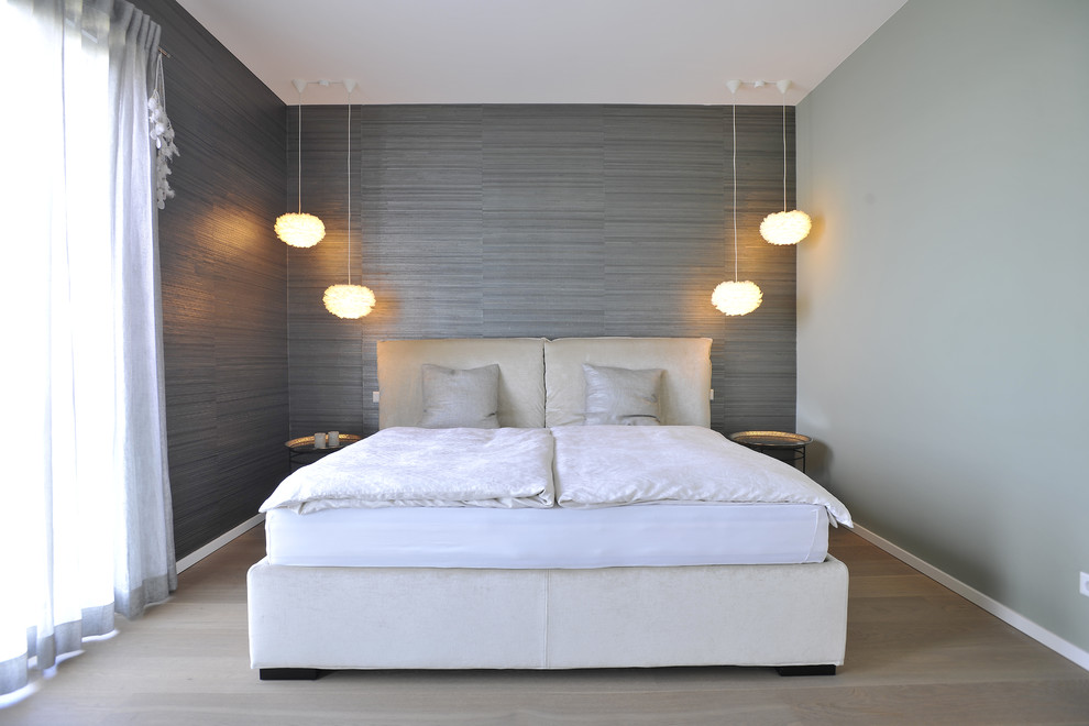 Ejemplo de dormitorio principal y gris y blanco contemporáneo de tamaño medio sin chimenea con paredes grises, suelo de madera en tonos medios y suelo marrón