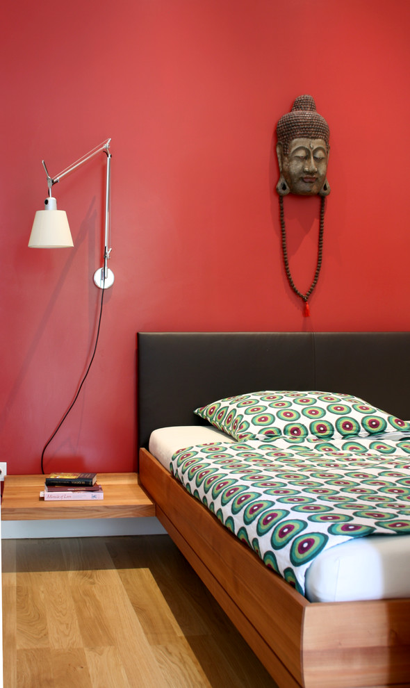 Inspiration pour une chambre design avec un mur rouge.