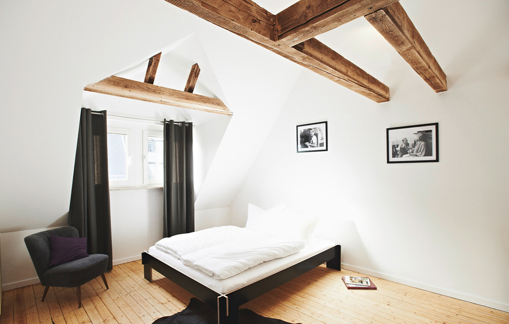 Modelo de dormitorio principal nórdico grande sin chimenea con paredes blancas y suelo de madera clara