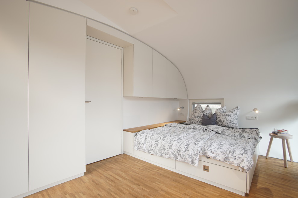 Idee per una camera da letto minimal di medie dimensioni con pareti bianche e pavimento in legno massello medio